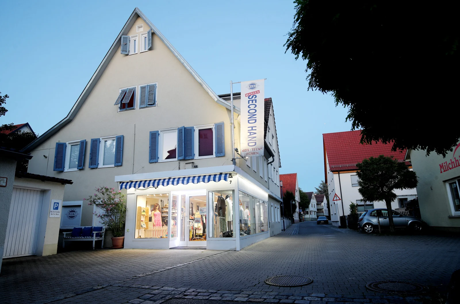 Das MUNZ-Geschäft in der Friedrichstraße 7 mit Schaufenstern und blau-weißer Markise